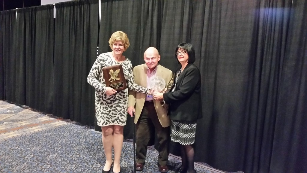 CARSTAR Mundelein co-owners Jeanne, left, and Jeff Silver, center, pose with Jeanne's Hall of Eagles award and Jeff Silver's I-CAR Chairman's Award. (John Huetter/Repairer Driven News)