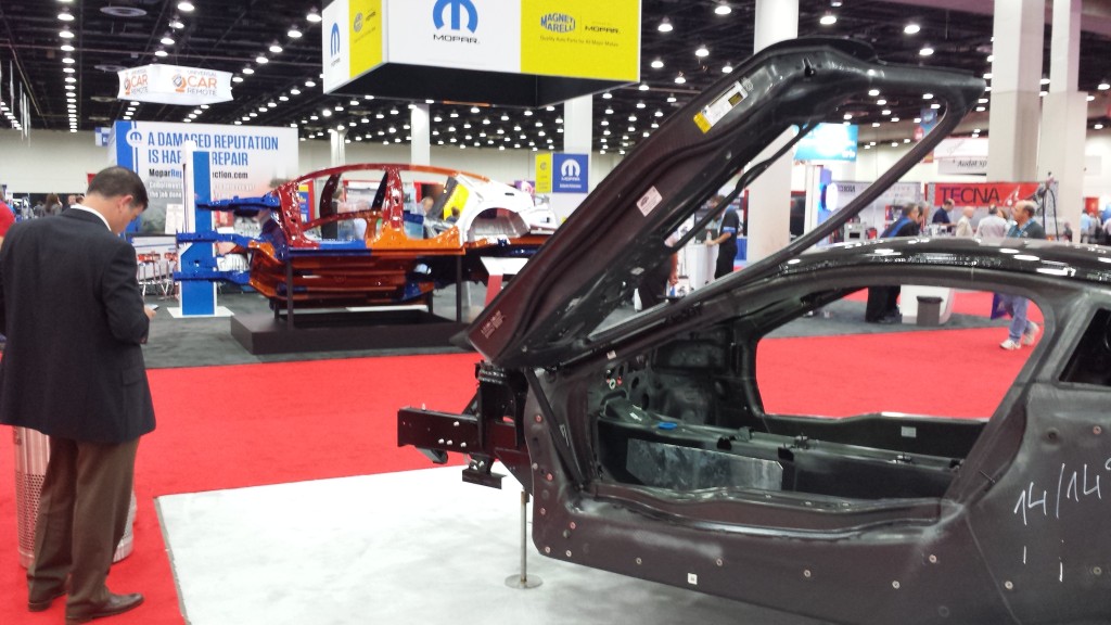 Future materials: Bodies-in-white of a carbon-fiber BMW i8, foreground, and ultra-high-strength steel Chrysler 200, background, are displayed at NACE|CARS in Detroit in July 2015. (John Huetter/Repairer Driven News)